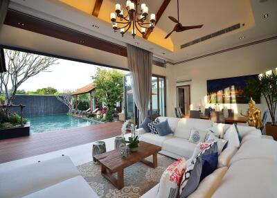 Modern living room with large windows opening to a pool area