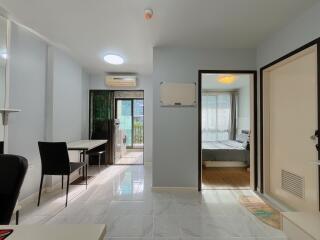 Modern living area with a view into a bedroom and balcony