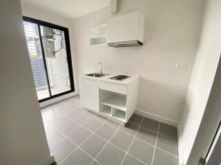 Modern compact kitchen with white cabinetry and stainless steel sink