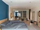 Spacious bedroom with large bed, blue accent wall, and modern wardrobe