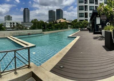 Outdoor pool area with lounge chairs and greenery