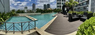 Outdoor pool area with lounge chairs and greenery