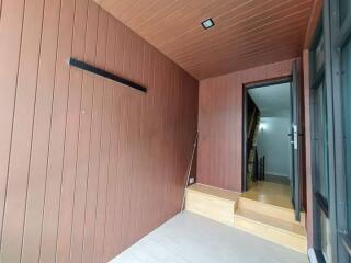 Entryway with wooden paneling and stairs leading to upper floor