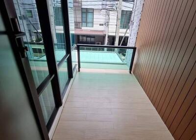 A small balcony with modern glass railing and city view