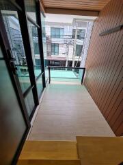 A small balcony with modern glass railing and city view