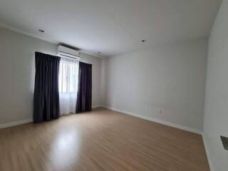 Spacious empty bedroom with window and dark curtains