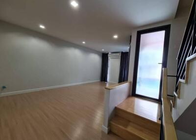 Spacious living room with wooden flooring, recessed lighting, large window and a staircase