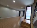 Spacious living room with wooden flooring, recessed lighting, large window and a staircase