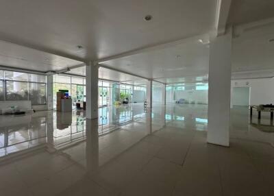 Spacious empty building interior with tiled flooring and large windows