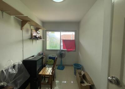 Small living area with window, shelving, and minimal furnishings