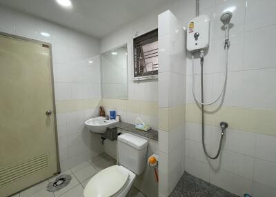 Modern bathroom with shower, toilet, sink, and water heater