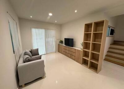 Minimalist living room with sofa, TV, and shelf