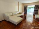 Spacious living room with a white sectional sofa and wooden flooring