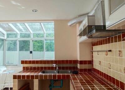 Modern kitchen with tiled countertops and large windows