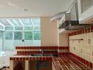 Modern kitchen with tiled countertops and large windows