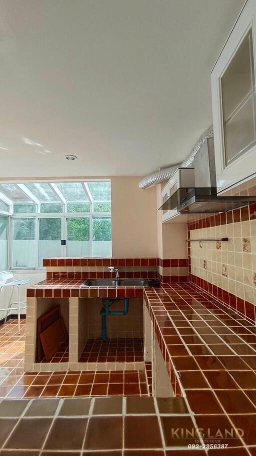 Modern kitchen with tiled countertops and large windows