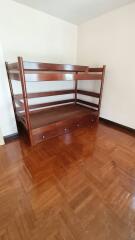 Bedroom with wooden bunk bed and polished wooden floor