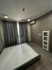 Spacious bedroom with large window, modern flooring, built-in air conditioning, and storage cabinet