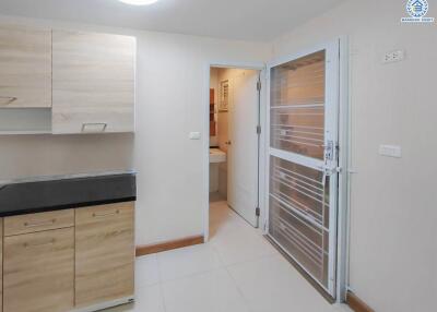 Modern kitchen with wooden cabinets and a metal door