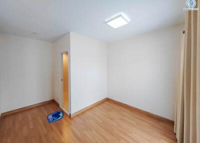 Empty bedroom with wooden flooring and white walls