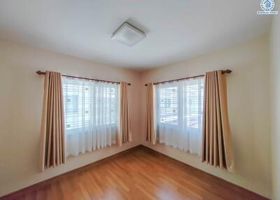 Bright bedroom with wooden floor and curtains