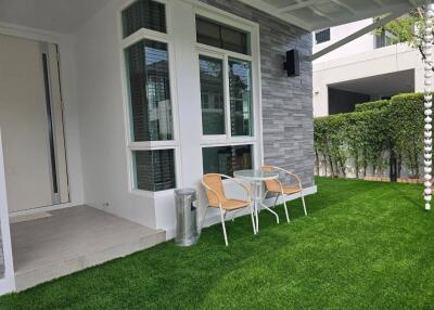 Exterior view with green lawn and seating area