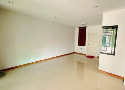 Empty living room with tiled floor and white walls