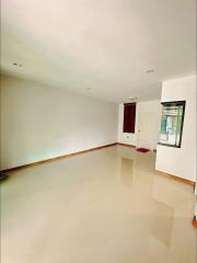 Empty living room with tiled floor and white walls