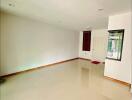 Empty living room with tiled floor and white walls