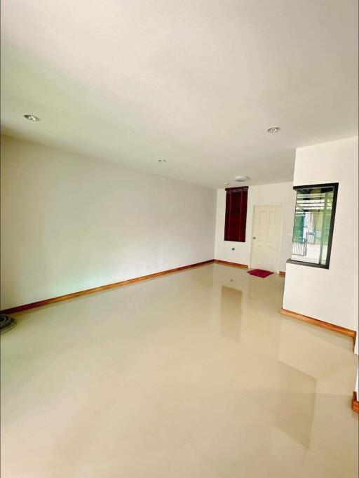 Empty living room with tiled floor and white walls