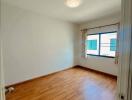 empty bedroom with wooden floor and window