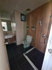 Modern bathroom with glass shower, sink, and toilet