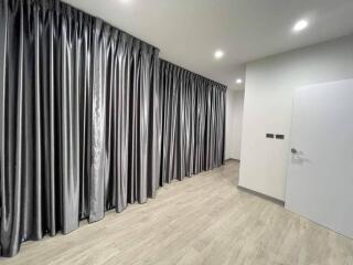 Bedroom with large windows covered by silver-gray curtains