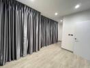 Bedroom with large windows covered by silver-gray curtains