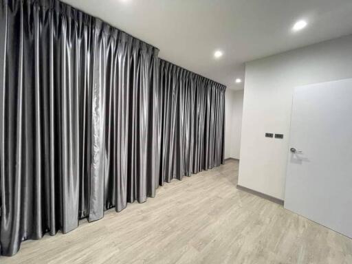 Bedroom with large windows covered by silver-gray curtains