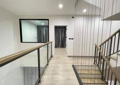 Modern hallway with glass railings and a wooden floor