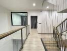 Modern hallway with glass railings and a wooden floor