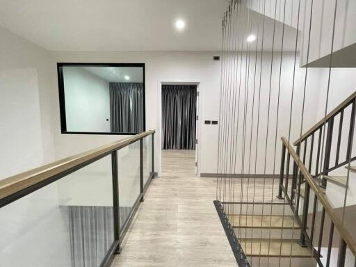 Modern hallway with glass railings and a wooden floor