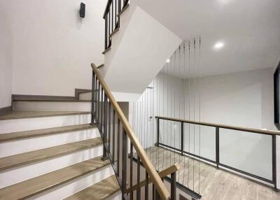 Modern staircase with metal railing and wooden steps