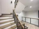 Modern staircase with metal railing and wooden steps