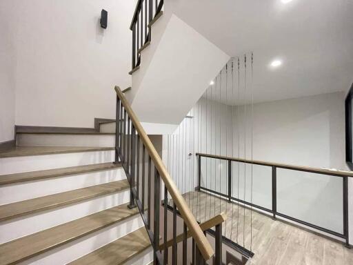 Modern staircase with metal railing and wooden steps