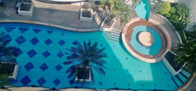 Outdoor swimming pool with palm trees and seating area