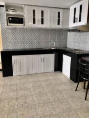 Modern kitchen with tiled backsplash and black-and-white cabinetry