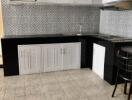 Modern kitchen with tiled backsplash and black-and-white cabinetry