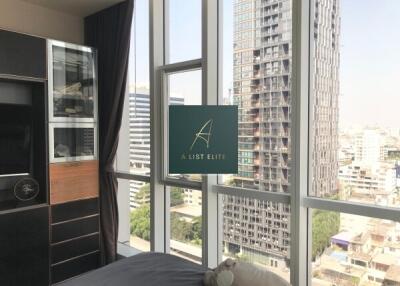 Bedroom with large windows and a view of the city