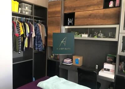 Bedroom with clothes on open shelves and study desk