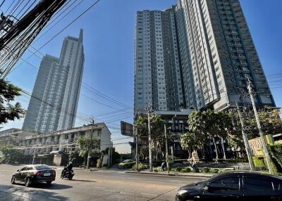 Street view of tall residential buildings under a clear blue sky