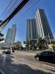 Street view of tall residential buildings under a clear blue sky