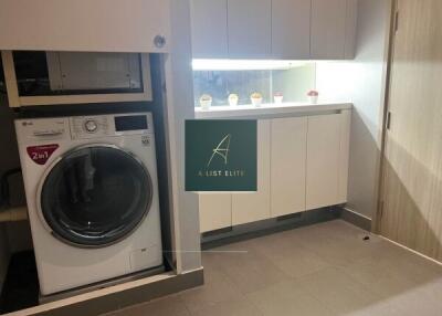 Laundry room with washer and cabinets