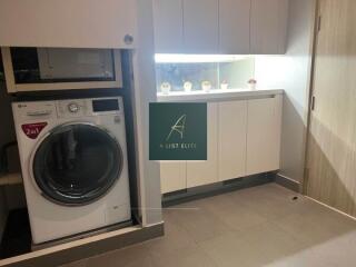 Laundry room with washer and cabinets